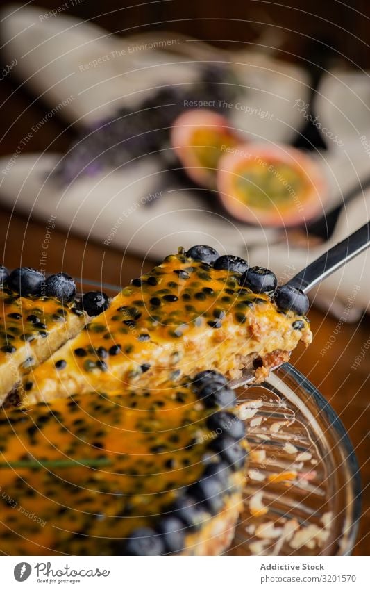 Schmackhaftes Stück Passionsfruchtkuchen mit Heidelbeere dekoriert Pasteten Orange Blaubeeren aufgeschnitten festlich natürlich Vegane Ernährung Lebensmittel