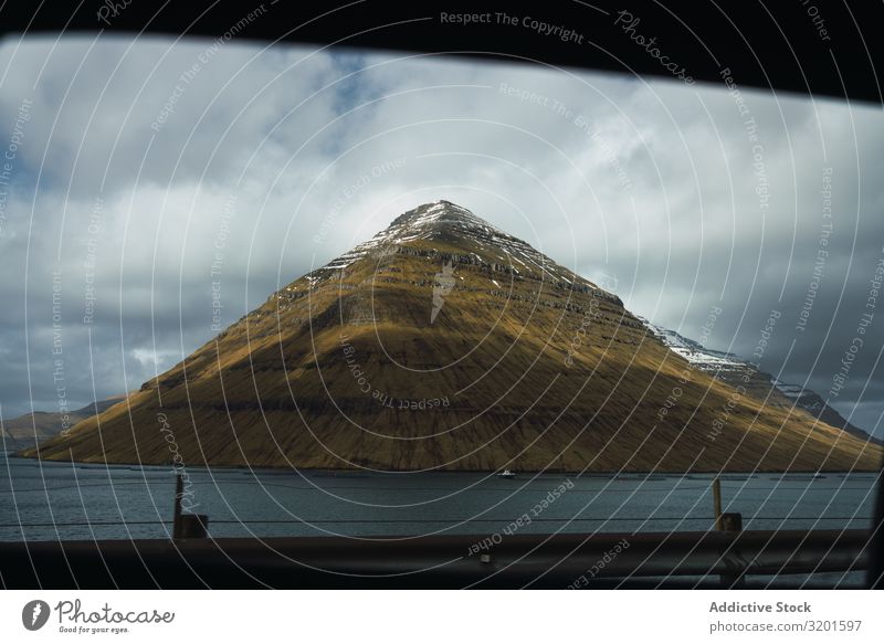 Erstaunliche Aussicht auf den See mit der grünen, verschneiten Klippe auf der Färöer-Insel Natur Tourismus Umwelt Dorf klein Haus Meer Wasser Landschaft