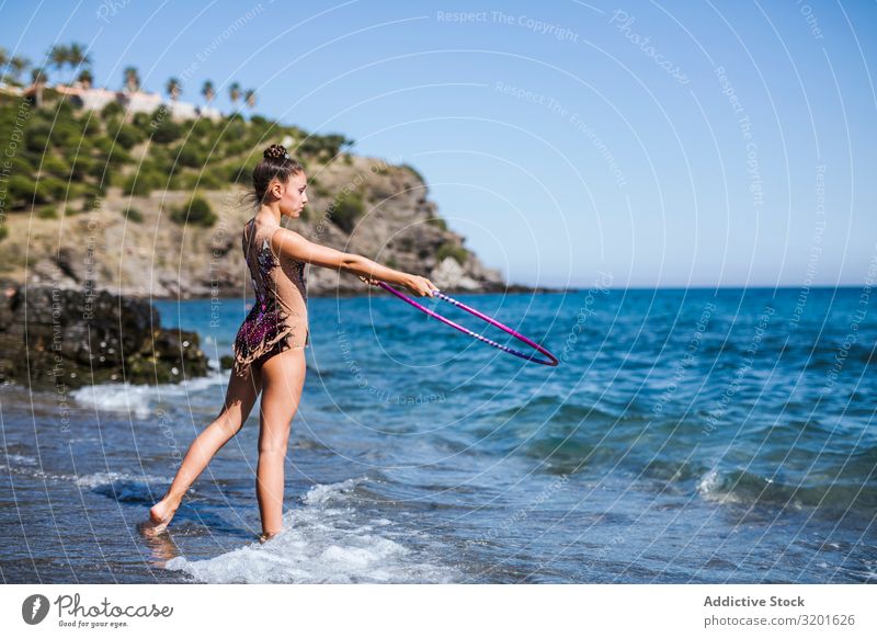 Anmutiger Akrobat mit Reifen am Strand Turner Frau rhythmisch Schnur Athlet üben Turnen Sport Jugendliche Mensch sportlich künstlerisch schön elegant beweglich