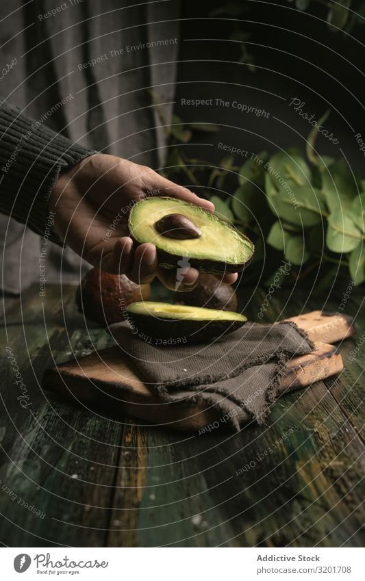 Person, die Avocados an den Händen hält geschnitten Diät exotisch Lebensmittel frisch Frucht grün Hälfte Gesundheit natürlich Natur Ernährung organisch roh reif