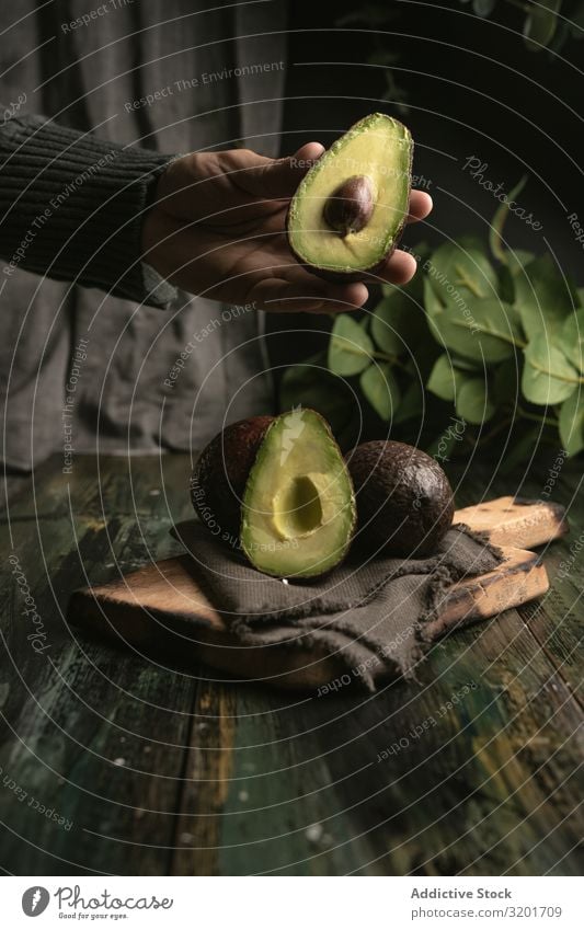 Person, die Avocados an den Händen hält geschnitten Diät exotisch Lebensmittel frisch Frucht grün Hälfte Gesundheit natürlich Natur Ernährung organisch roh reif