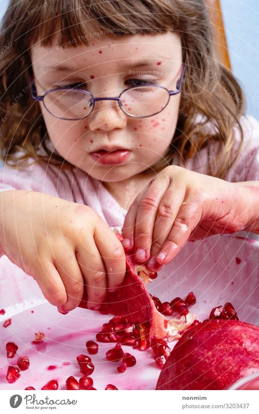 Mädchenschale Granatapfel. Gesicht verschmutzt von roten Flecken Frucht Dessert Ernährung Vegetarische Ernährung Kind Brille dreckig frisch natürlich Neugier