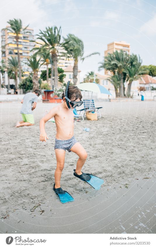 Junge mit Schnorchelmaske und Schwimmflossen am Strand Flosse Maske Ferien & Urlaub & Reisen Sommer Kindheit spielerisch Erholung Meer Küste Freizeit & Hobby