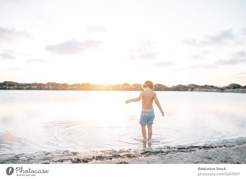 Junge geht im Wasser des Sees Strand Sommer erkunden laufen Kind Sonnenuntergang Kindheit Freizeit & Hobby Ferien & Urlaub & Reisen hell träumen Einsamkeit