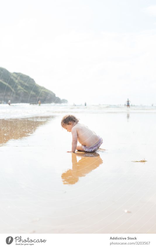 Kleinkind am feuchten, sonnigen Strand Baby Sonnenlicht Sommer Küste Kind Wasser unschuldig Ferien & Urlaub & Reisen Freizeit & Hobby Spielen ruhen Freude Natur