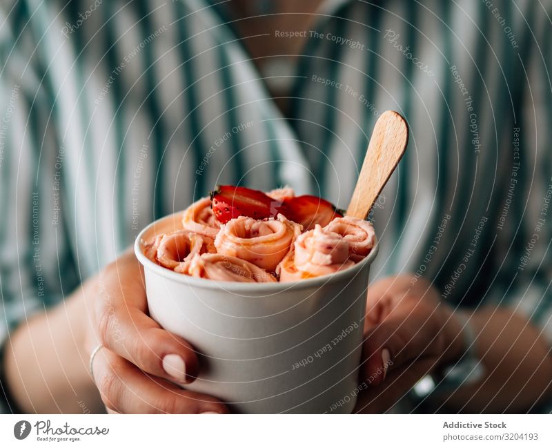 Handgehaltenes gerolltes Eis in Tütenbecher Brötchen Speiseeis Erdbeeren Frau Creme Eiscreme backen Frucht braten Kopie Weltall Textfreiraum Hintergrundbild