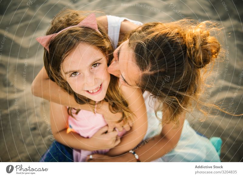 Frau mit Tochter am sonnigen Strand Liebe Umarmen Familie & Verwandtschaft Sommer Mutter Zusammensein Mädchen Sand Eltern Ferien & Urlaub & Reisen Bonden