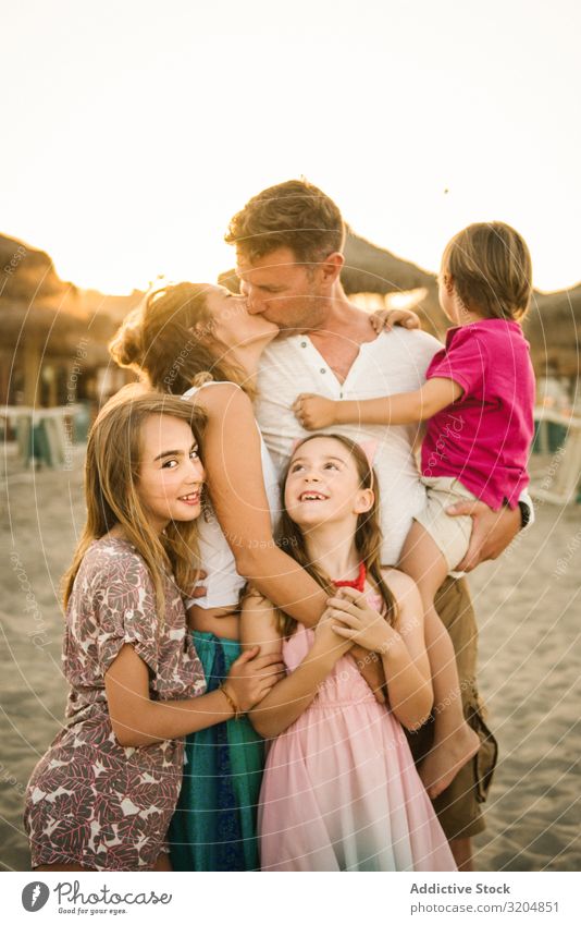 Schöne glückliche Familie mit Kindern am Strand Familie & Verwandtschaft Eltern Liebe Küssen Glück Menschengruppe Geschwisterkind Sommer