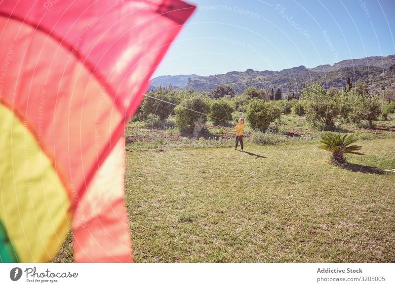 Junge startet Drachen am Sommertag Lenkdrachen Himmel Freude Kindheit Spielen fliegen Landschaft klein Mensch Aktion spielerisch lässig Unbekümmertheit heiter