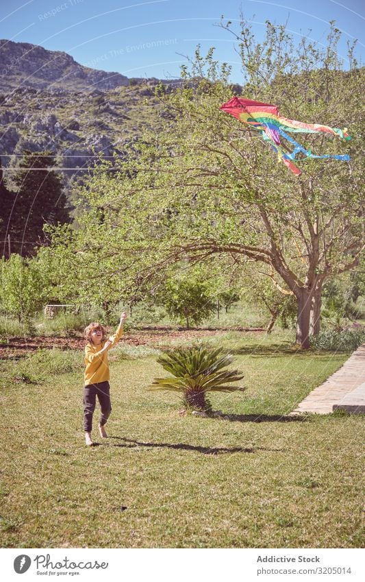 Junge startet Drachen am Sommertag Lenkdrachen Himmel Freude Kindheit Spielen fliegen Landschaft klein Mensch Aktion spielerisch lässig Unbekümmertheit heiter