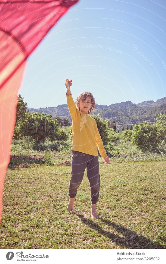 Junge startet Drachen am Sommertag Lenkdrachen Himmel Freude Kindheit Spielen fliegen Landschaft klein Mensch Aktion spielerisch lässig Unbekümmertheit heiter