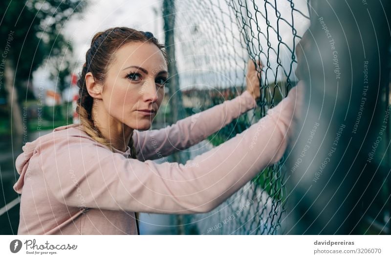 Sportliches Mädchen auf dem Sportplatzzaun ruhend Lifestyle schön Körper Freizeit & Hobby Mensch Frau Erwachsene Wolken Regen Fitness authentisch selbstbewußt