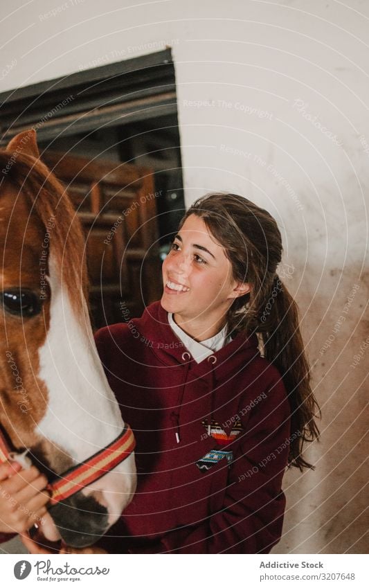 Mädchen mit entzückendem Pony mit Hut Teenager Ponys Pferdestall Tier Kind Umarmen Freund Haustier Kindheit Landschaft Kraulen wenig niedlich charmant Bauernhof