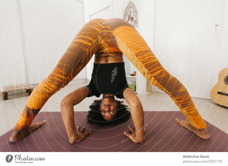 Frau mit geschlossenen Augen steht mit der Hand nach unten auf der Matte praktizieren Yoga positionieren Sitzen Erholung Übung Kopf schön Fitness Sport Freizeit