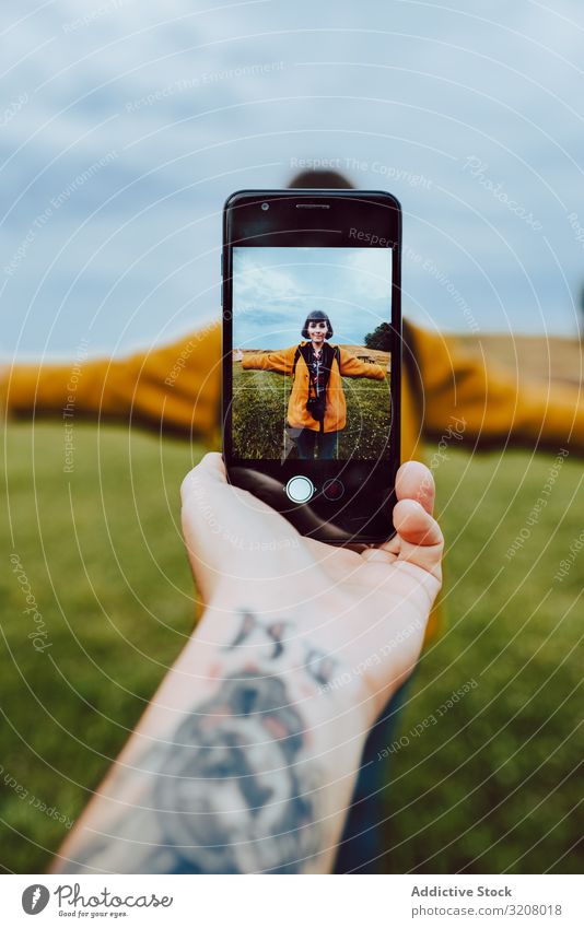 Handaufnahme einer Frau auf dem Feld Foto Smartphone Tattoo ausgestreckte Arme Freiheit Lifestyle Freizeit reisen Ausflug Reise Wochenende Mobile Telefon