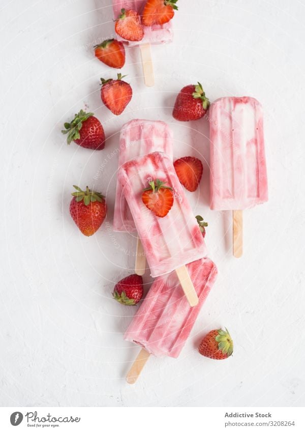 Rosa Eis am Stiel und frische Erdbeeren Stieleis Eiscreme rosa erfrischend Freeze Pop lecker kalt eisbedeckt Sommer süß Dessert Lebensmittel fruchtig Beeren