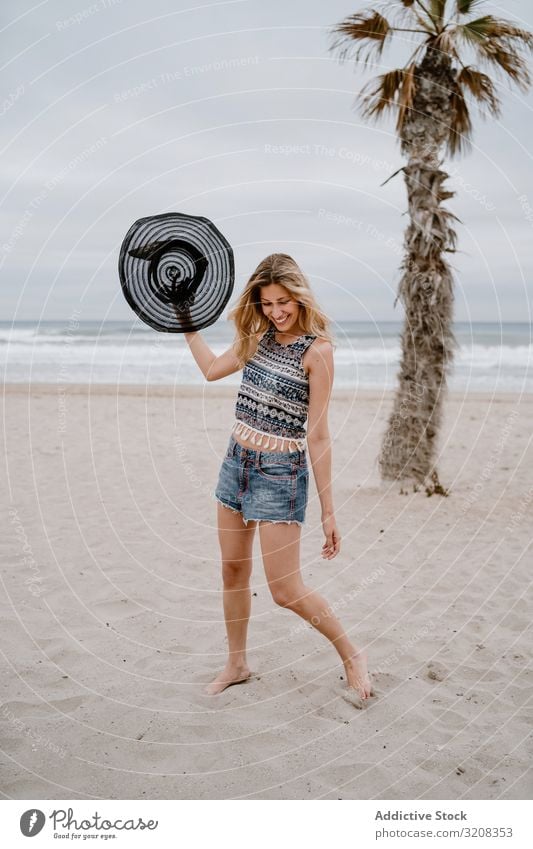 Junge Frau entspannt sich am Strand mit Hut modisch Sommer Urlaub reisen Erholung Feiertag Resort jung Person attraktiv schlank schön spielerisch blond hübsch