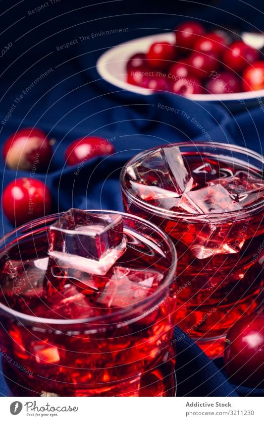 Rotes Getränk in der Nähe von frischen Früchten auf Stoff rot Frucht Glas Gewebe kalt Cocktail Pflaume Eis Portion Würfel trinken Sommer Erfrischung Saft