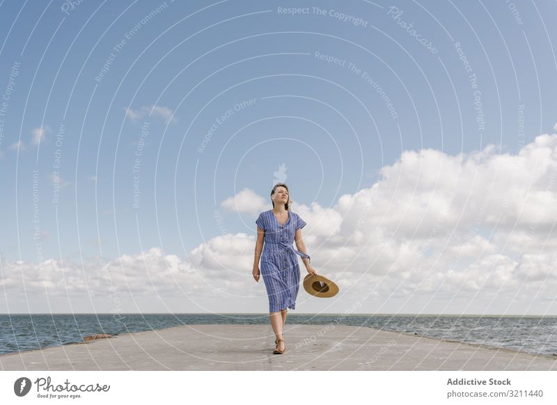 Junge Frau am Seekai MEER Pier laufen Freiheit Flucht Bewegung Horizont Strohhut Landschaft Seeküste Hafengebiet Haltehut Ausflugsziel Bucht Sonnenkleid Beton