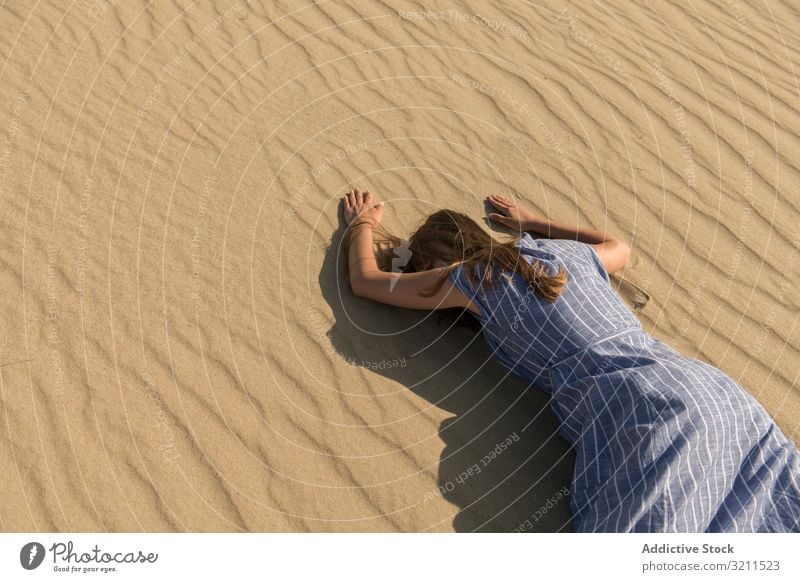 Junge Frau auf Sanddüne liegend wüst müde Düne heiß mit dem Gesicht nach unten Durst erschöpft Sonnenlicht lässig Dürre Sommer Kleid Freiheit nida Litauen Gras