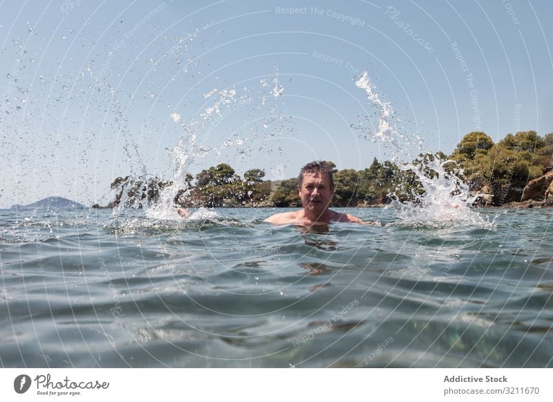 Aktive Senioren schwimmend und plantschend im Wasser Mann Schwimmsport platschen älter in den Ruhestand getreten reisen Schnurrbart Urlaub halkidiki