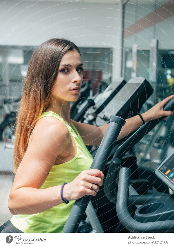 Junge Frau übt an moderner Maschine Herz Fitnessstudio Athlet Übung Zusammensein Training Sport Team Aufwärmen Kraft jung passen Gesundheit Wellness