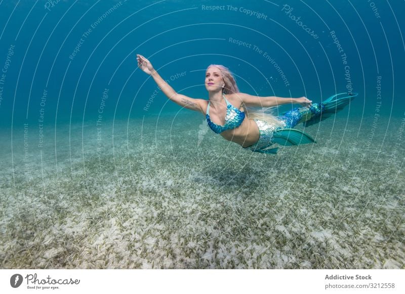 Blonde märchenhafte Meerjungfrau schwimmt unter Wasser schwimmen sorgenfrei Fischschwanz blau MEER tief blond schön Tageslicht Frau glänzend lange Haare hell