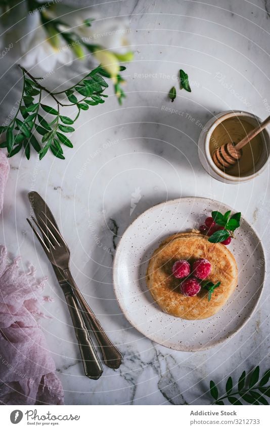 Pfannkuchen mit frischen Himbeeren auf Teller gold-braun Minze Murmel Tischplatte Frühstück geschmackvoll Blätter stylisch weiß Servieren Garnierung Dessert