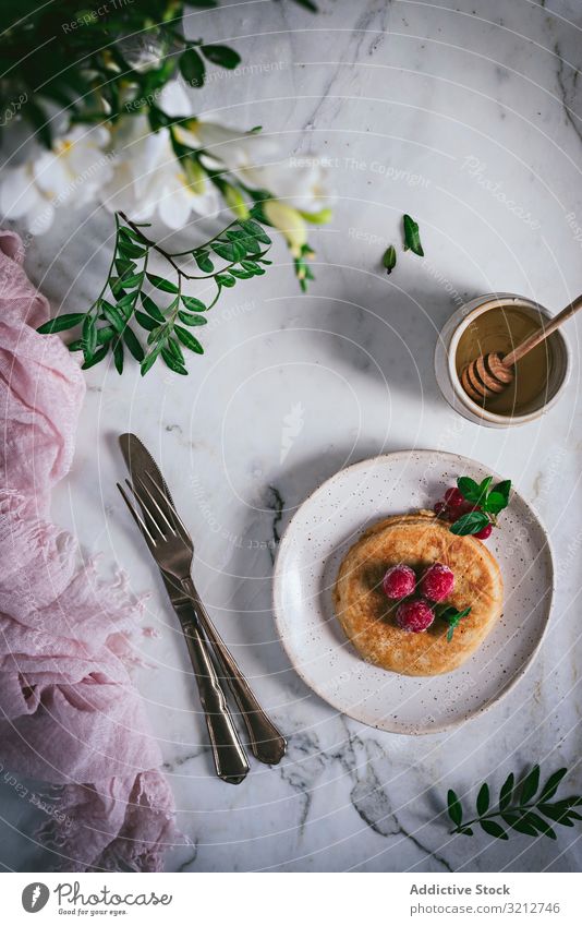 Pfannkuchen mit frischen Himbeeren auf Teller gold-braun Minze Murmel Tischplatte Frühstück geschmackvoll Blätter stylisch weiß Servieren Garnierung Dessert