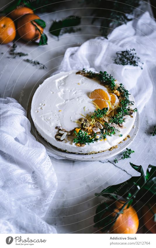 Mandarinenkuchen, dekoriert mit Schlagsahne und Zitrusfrüchten in Scheiben geschnitten Kuchen Bäckerei lecker geschmackvoll Dessert süß Messer Löffel orange