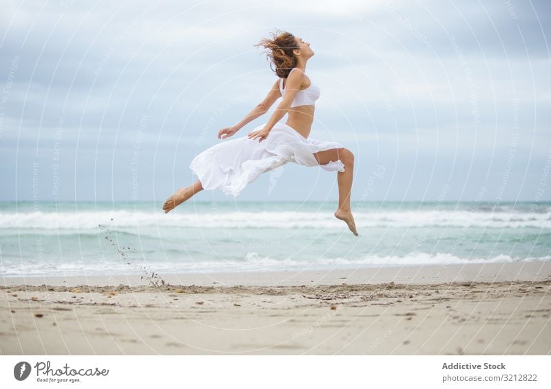 Schöne Frau tanzt am Meer Tanzen MEER Sand Ufer Freiheit Konzept Natur Wellen Wetter Bewegung Körperhaltung weiß Outfit Küste Strand Wasser sorgenfrei Dame