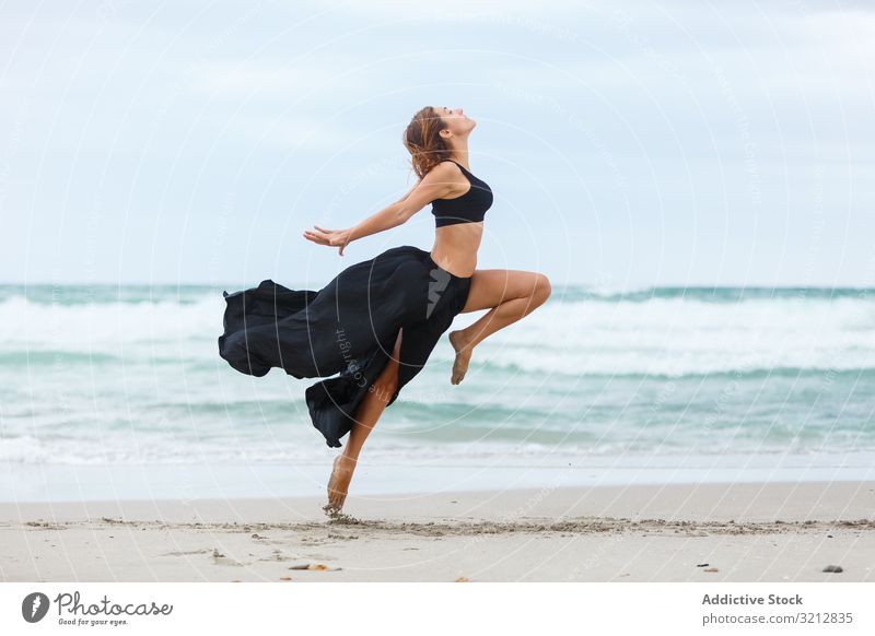 Schöne Frau tanzt am Meer Tanzen MEER Sand Ufer Freiheit Konzept Natur Wellen Wetter Bewegung Körperhaltung schwarz Outfit Küste Strand Wasser sorgenfrei Dame