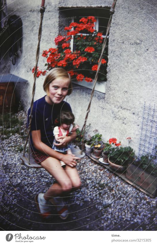 Flugbegleiterin Schaukel feminin Mädchen 1 Mensch Baum Beet Haus Mauer Wand T-Shirt blond langhaarig Kiesbett Puppe festhalten Lächeln Blick sitzen Glück