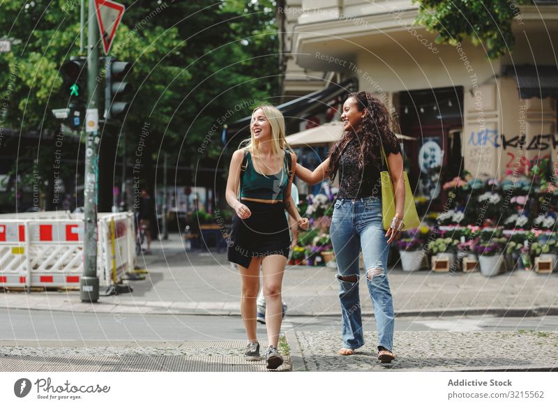 Fröhliche Freunde gehen auf der Straße der Stadt Frau Spaziergang Berlin Großstadt Sommer Zusammensein Bonden Lächeln heiter jung Glück Freundin schön sonnig