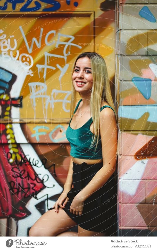 Stilvolle Frau mit Sonnenbrille posiert an Graffiti-Wand auf Stadtstraße. stylisch Straße urban posierend Porträt attraktiv Schönheit trendy Lifestyle hübsch