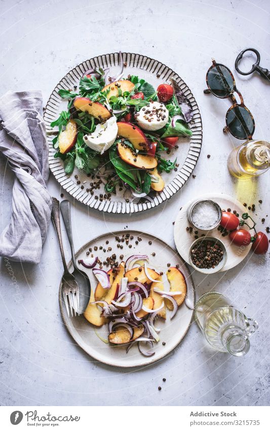 Salat mit Nektarinen und knusprigen Linsen Salatbeilage Pfirsich Zwiebel Tomate Kirsche Käse Paprika Scheibe Salz rot schwarz Lebensmittel Gewürz Vegetarier