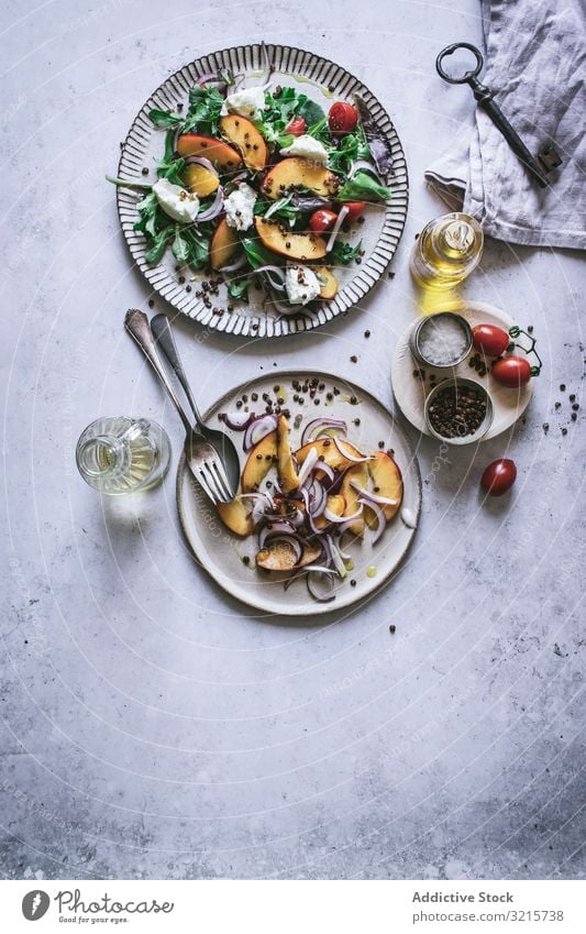 Salat mit Nektarinen und knusprigen Linsen Salatbeilage Pfirsich Zwiebel Tomate Kirsche Käse Paprika Scheibe Salz rot schwarz Lebensmittel Gewürz Vegetarier