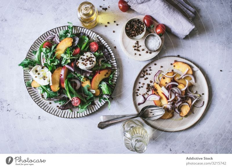 Salat mit Nektarinen und knusprigen Linsen Salatbeilage Pfirsich Zwiebel Tomate Kirsche Käse Paprika Scheibe Salz rot schwarz Lebensmittel Gewürz Vegetarier