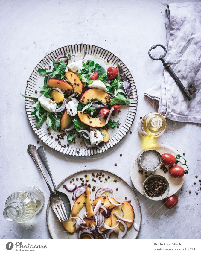 Salat mit Nektarinen und knusprigen Linsen Salatbeilage Pfirsich Zwiebel Tomate Kirsche Käse Paprika Scheibe Salz rot schwarz Lebensmittel Gewürz Vegetarier