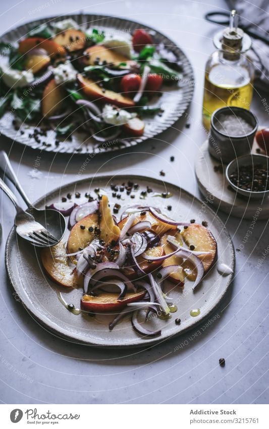 Salat mit Nektarinen und knusprigen Linsen Salatbeilage Pfirsich Zwiebel Tomate Kirsche Käse Paprika Scheibe Salz rot schwarz Lebensmittel Gewürz Vegetarier