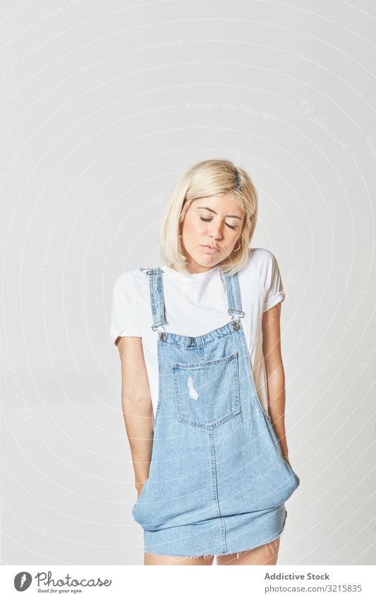 Trendige blonde Frau im Denim-Sonnenkleid modisch stylisch glamourös trendy Jeanshose Jeansstoff jung Person schön attraktiv hübsch schlank nachdenklich