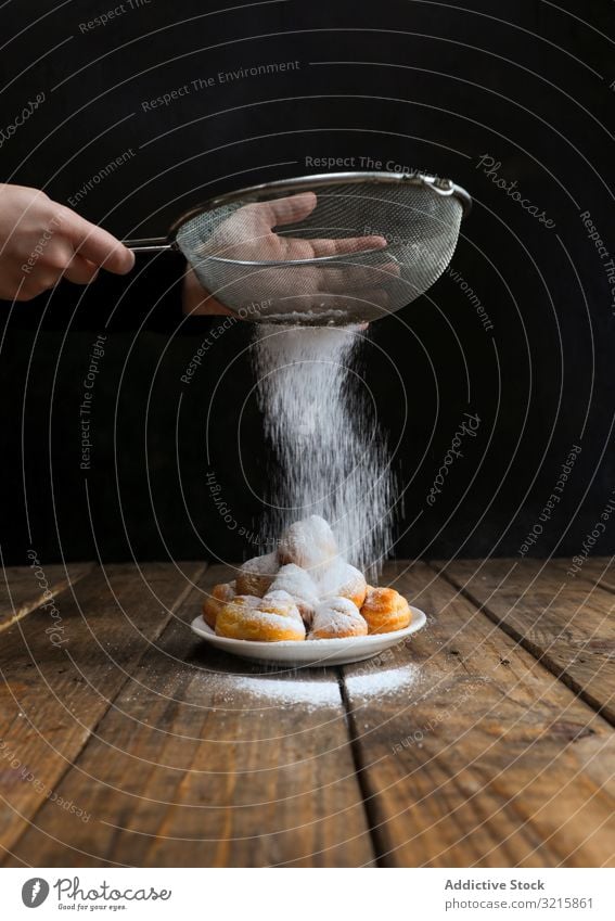 Person, die Kekse mit Puderzucker bestreut Zucker bestäuben Lebensmittel Biskuit Gebäck Sieb selbstgemacht Zuckerguß Küchenchef süß lecker Pulver Bäckerei