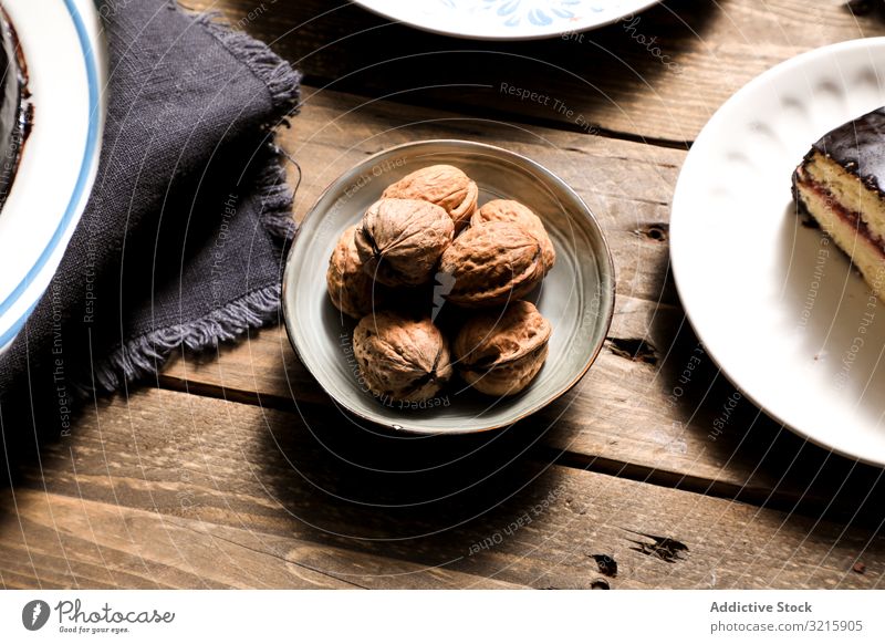 Nüsse in Schalenkuchen und Serviette auf dem Tisch Muttern Kuchen Stoff Dessert selbstgemacht Lebensmittel Bäckerei Essen zubereiten süß braun ungeschält