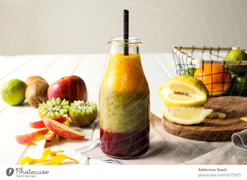 Flasche mit geschichtetem Smoothie Frucht Schichten Stroh Gesundheit Tisch sortiert mischen süß Lebensmittel Diät frisch organisch Glas Dessert Kiwi Apfel