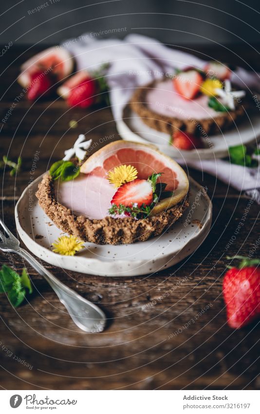 Erdbeer- und Zitruskuchen auf Holztisch serviert Erdbeeren Zitrusfrüchte Kuchen Dessert Layout dienen Dekoration & Verzierung rustikal Tisch Teller Beeren Gabel