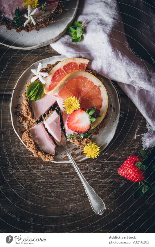 Erdbeer- und Zitruskuchen auf Holztisch serviert Erdbeeren Zitrusfrüchte Kuchen Dessert Layout dienen Dekoration & Verzierung rustikal Tisch Teller Beeren Gabel