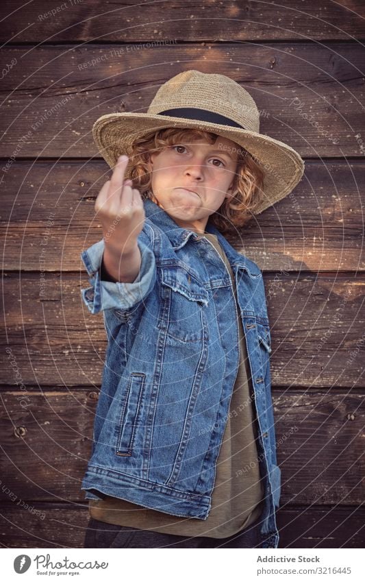 Frecher selbstbewusster Junge gestikuliert Fick dich gestikulierend Stehen Kind wenig Mitte Finger obszön zeigend Spaß lässig Sommer lustig aktiv Freiheit Hand