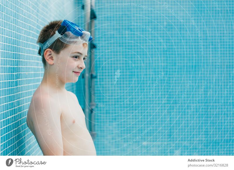 Junge mit Ball im leeren Becken stehend Schutzbrille Pool Kind Wand Kindheit spielen Spiel Freizeit Spaß Aktivität spielerisch männlich Lächeln Entertainment