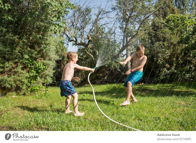 Kleine Kinder in Badebekleidung haben Spaß mit Spritzwasser Geplätscher Wasser Sommer Spielen Glück Lifestyle Freizeit Erholung Feiertag Kindheit Freude Genuss