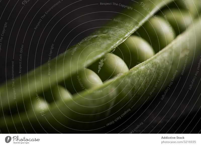 Frische Erbsen und Erbsenschoten auf dunklem Hintergrund ökologisch Lebensmittel frisch grün Gesundheit Hülsenfrüchtler natürlich organisch roh Samen Gemüse